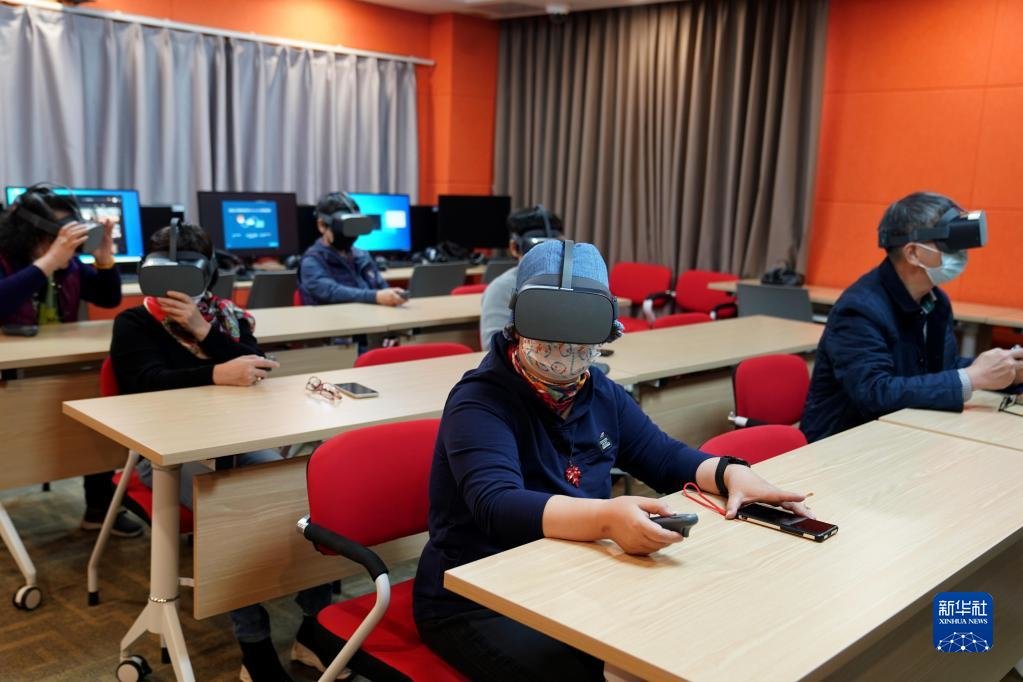 2021年11月26日，在上海老年大学钦州书院“科技岛”教室，学员通过VR虚拟体验“环球旅行”。新华社记者 刘颖 摄